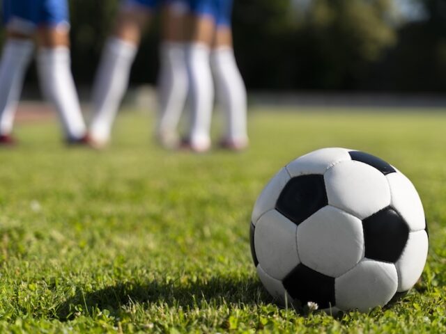 Fotbollsplan, boll och spelare